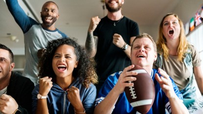 group of friends watching football, smiling
