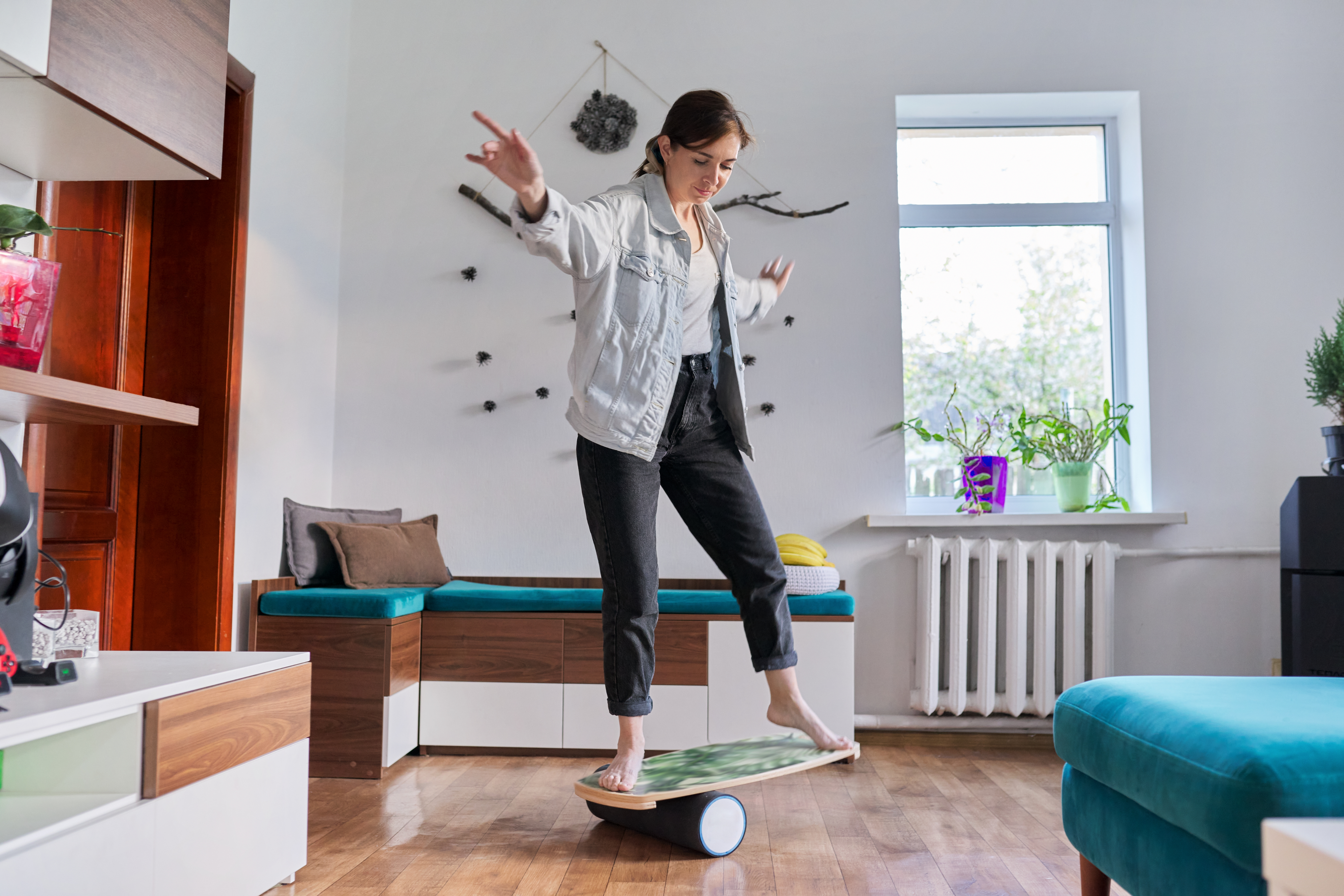 mature woman on a balance board in her living room
