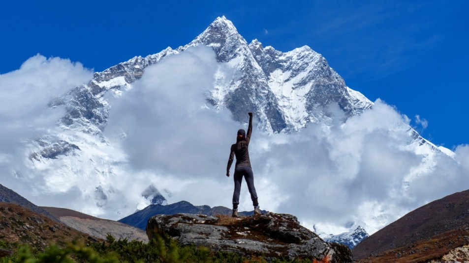 Active hiker hiking, enjoying the view, looking at mount Everest landscape. Travel sport lifestyle concept
