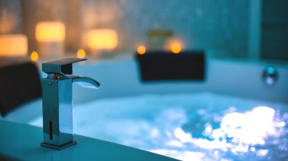 Blue bubbling Water in Spa Jacuzzi close-up faucet decorated with candles on the background, Relax and Lifestyle Abstract Background with blue lights beauty