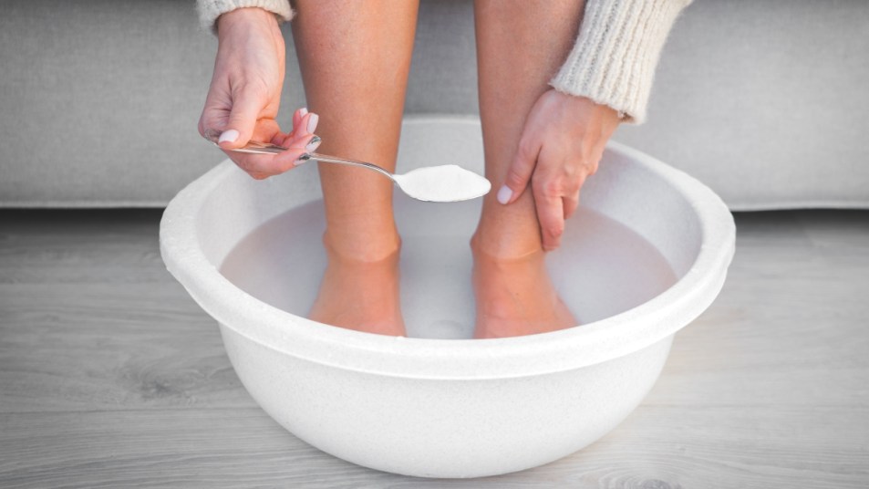 way to use baking soda - woman putting it in her foot bath