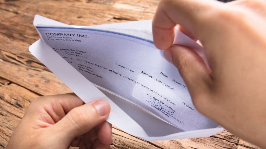 woman opening a paycheck in envelope cropped