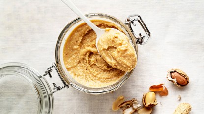 A jar of natural peanut butter as part of a guide on how to prevent it from becoming oily