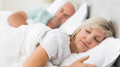 A mature couple sleeping in the same bed