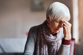 Shot of a senior woman experiencing a headache, constant fatigue, in a retirement home