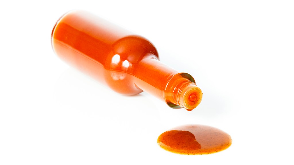 A bottle of hot sauce tipped over before being added to coffee