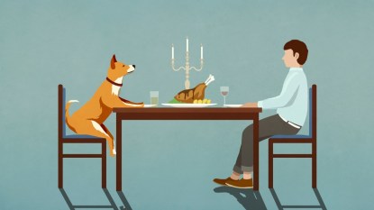 Man and dog enjoying candlelight dinner at table