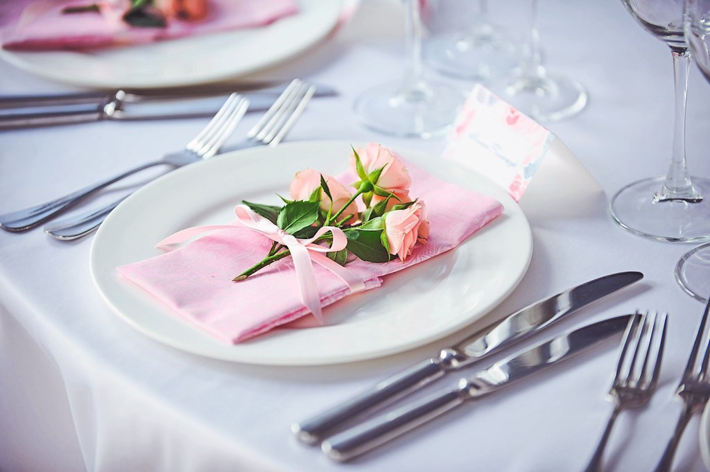 Banquet service with pink napkins, glasses, pink bouquets