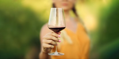 Red wine glass in the hand of a woman