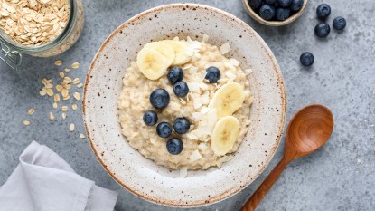 A bowl of oatmeal with bananas and blueberries