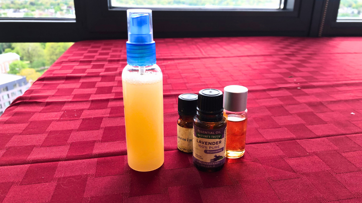 DIY poo pourri on red tablecloth next to essential oils