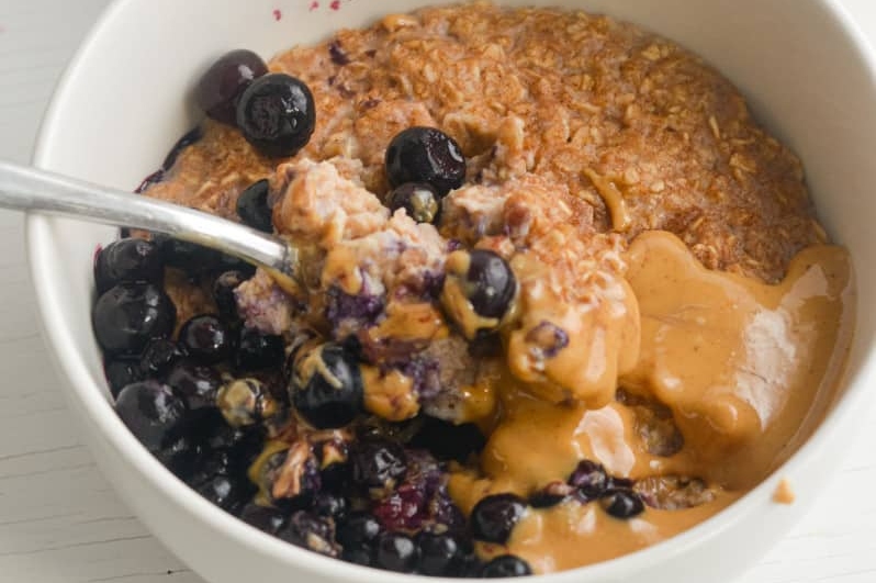 bowl of sweet egg white oatmeal with blueberries and peanut butter