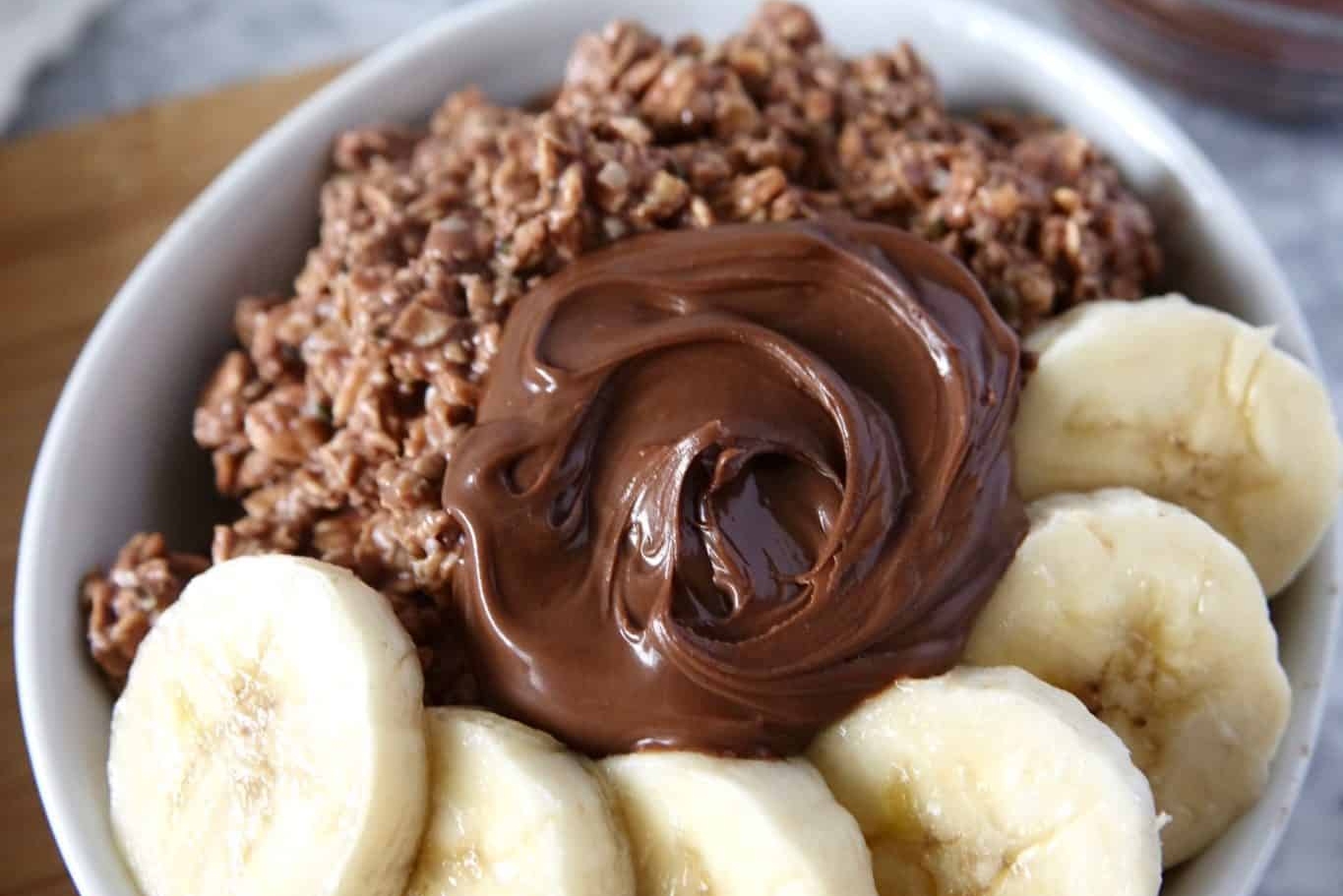 nutella overnight oats with banana in white bowl