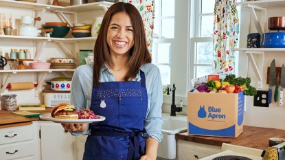 Chef Molly Yeh with plate of burgers and blue Apron box