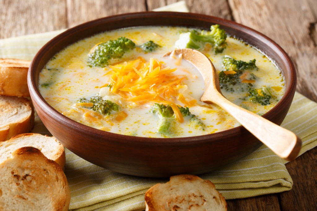 Spicy thick creamy broccoli cheese soup in a bowl with toast close-up on the table. horizontal
