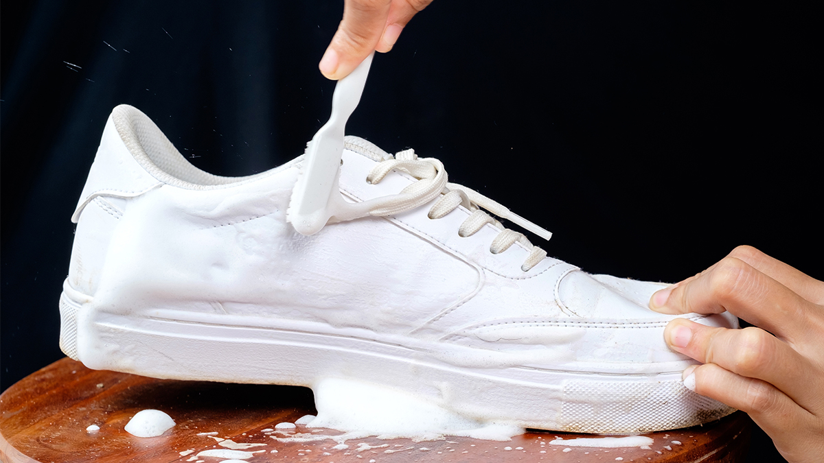 white sneakers being scrubbed with toothbrush
