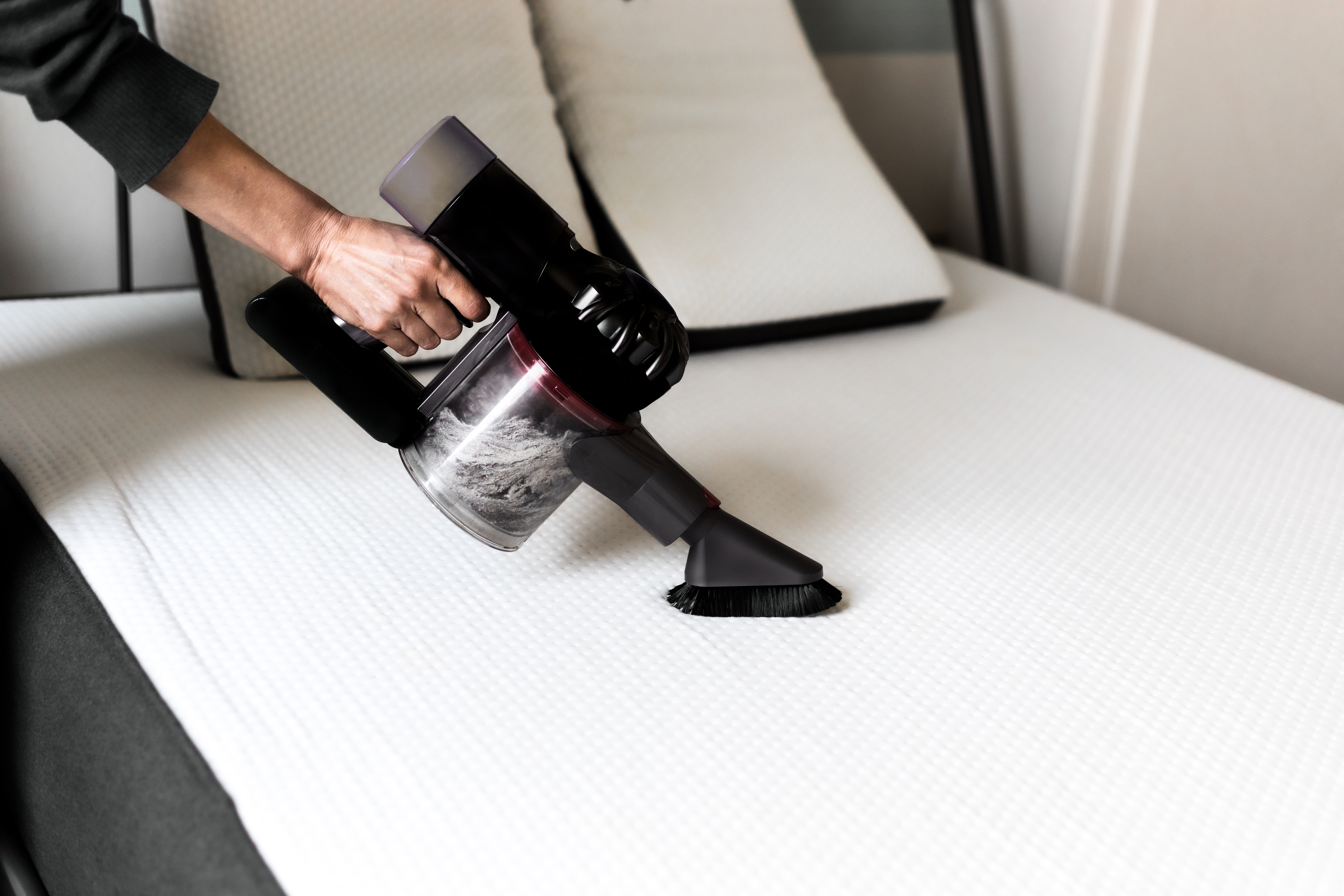 A woman vacuuming her memory foam mattress