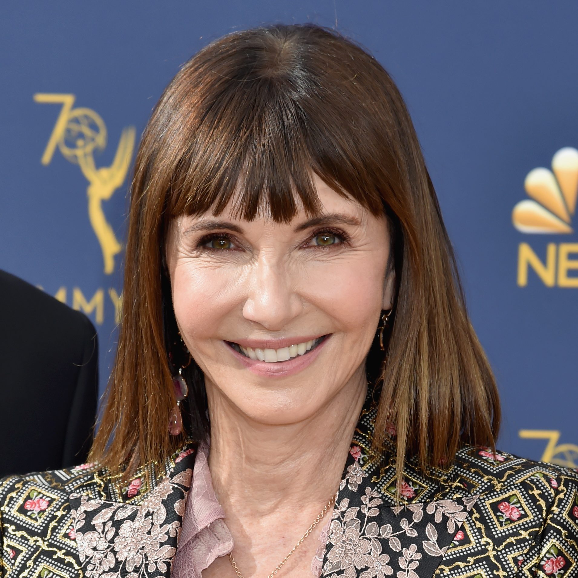 Mary Steenburgen smiling on the red carpet with full, blunt bangs