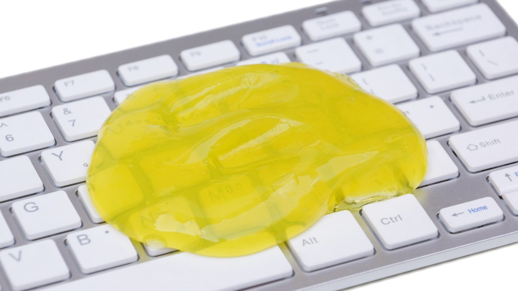 DIY cleaning putty (made from white glue, borax and water) spread over keyboard keys