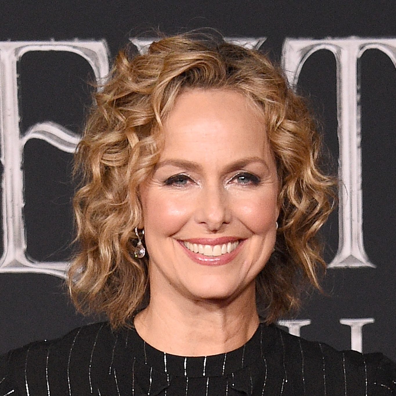Melora Hardin smiling with curly hair