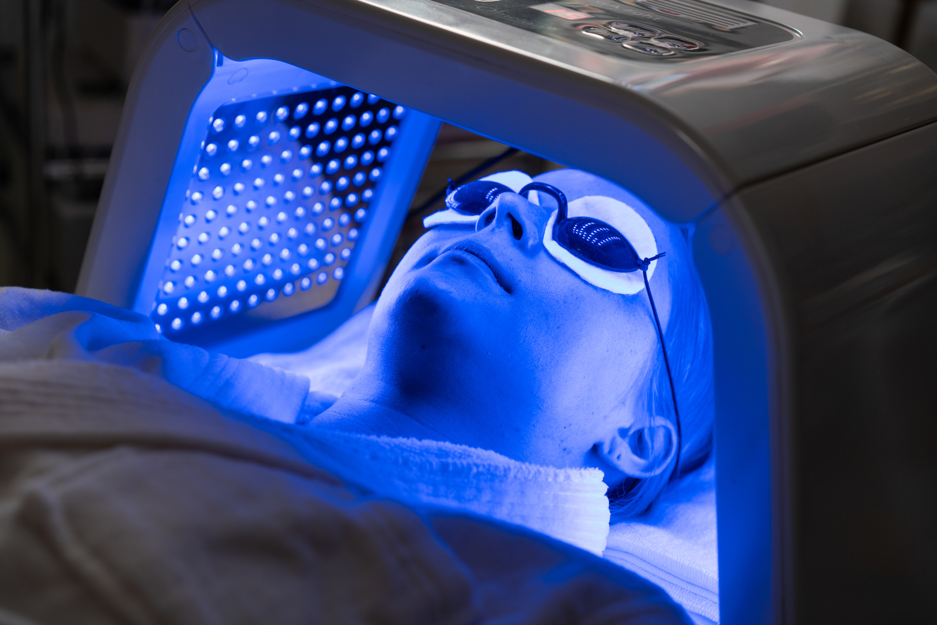 woman getting blue light therapy in office