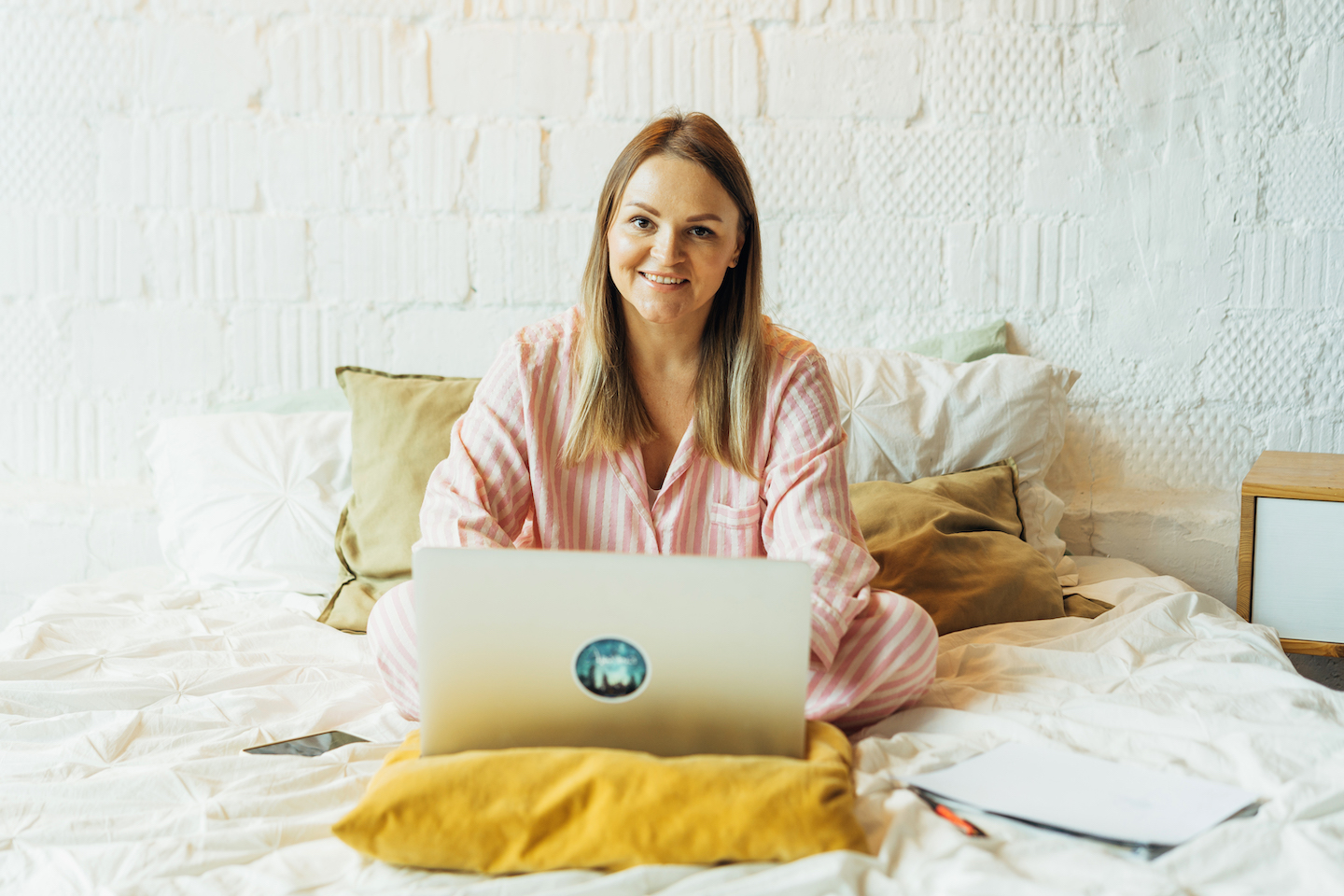 woman working on her laptop from bed while in pajamas (Work from home Walmart)