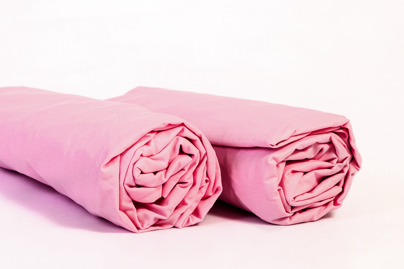 Pink fitted sheets an how to fold them into log rolls