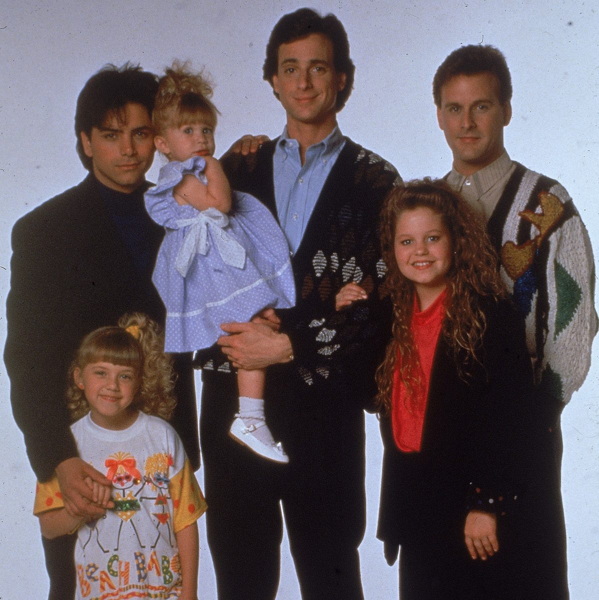 Portrait of the cast of the television program, 'Full House,' (left - right): John Stamos, Jodie Sweetin, Ashley or Mary-Kate Olsen, Bob Saget, Candace Cameron, and David Coulier, c. 1989.
