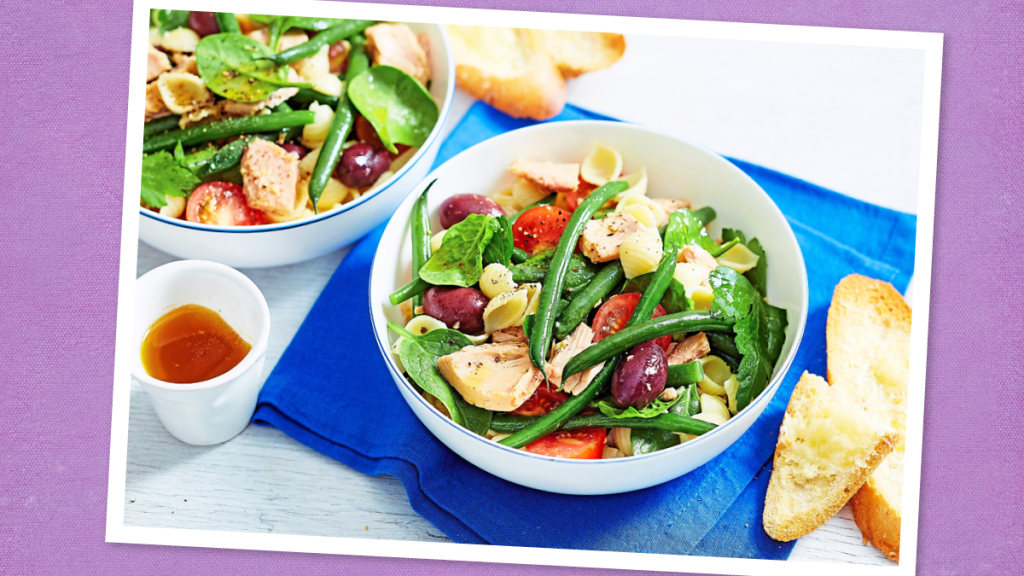 Mediterranean Veggie Salad sits on a white bowl (canned tuna recipes)