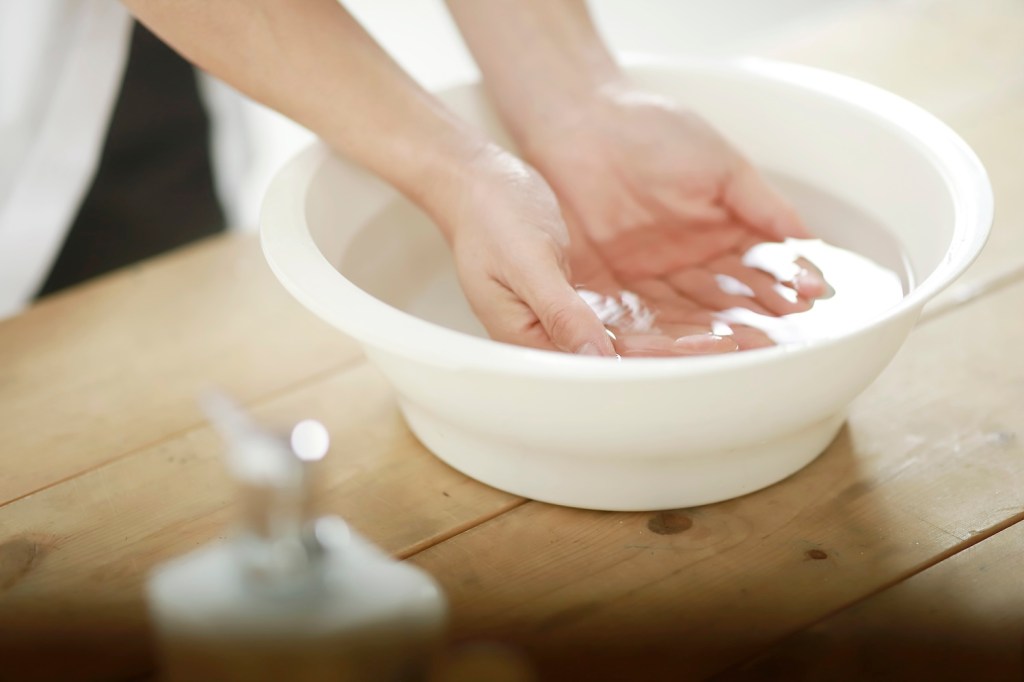 Close up of woman washing hands in bowl