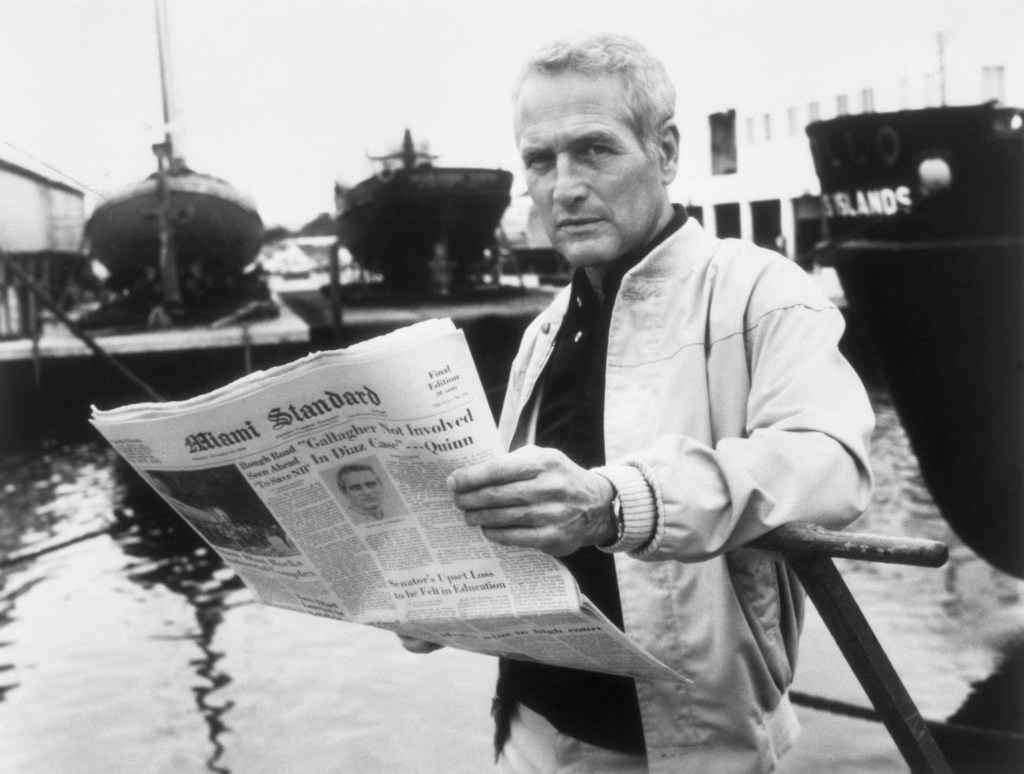 Actor Paul Newman young in a scene form the movie: "Absence of Malice." Newman is shown with a copy of The Miami Standard looking at the camera.