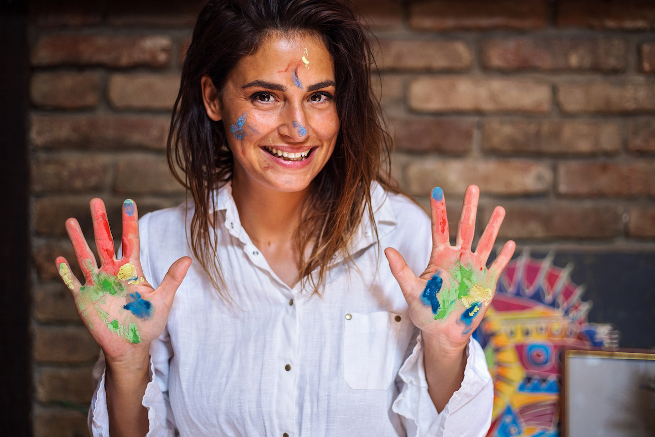 Woman with paint on her hands and face