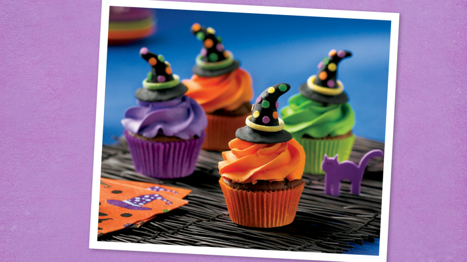 Rainbow Witch Hat Cupcakes sits on a table (halloween cupcakes)
