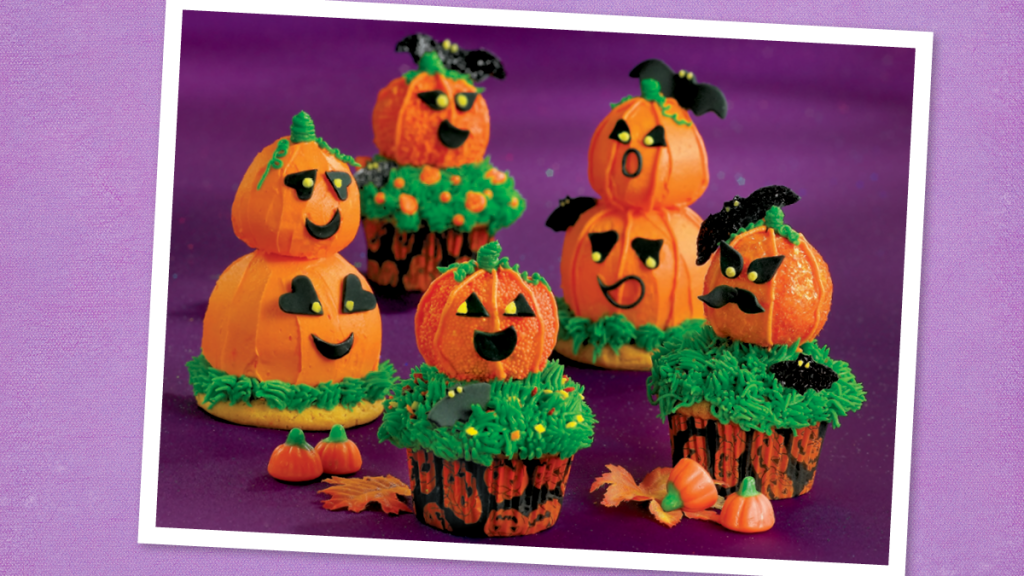 Jack O’-Lantern Cupcakes sit looking cute (scary cupcakes)