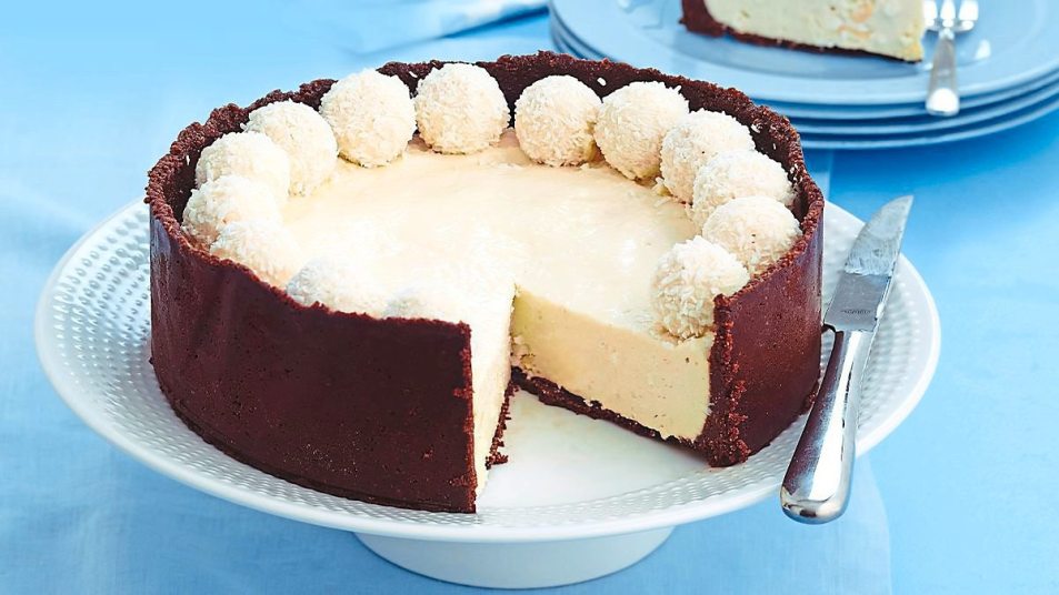Coconut Snowball Cheesecake sits on some blue (coconut desserts)
