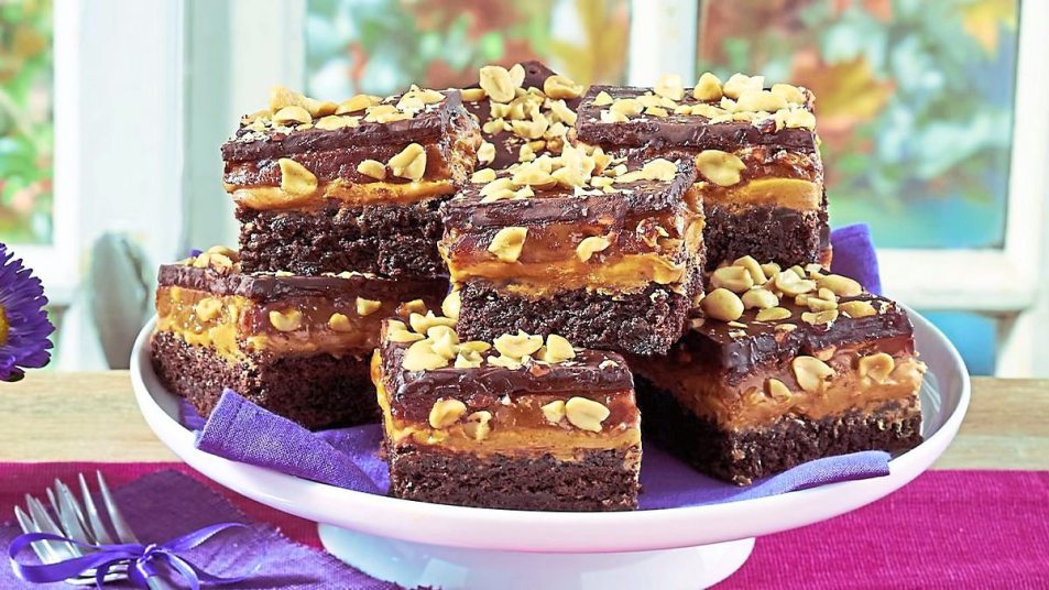 Stacked Peanut Butter & Caramel Brownies sits on a white plate (peanut butter desserts)