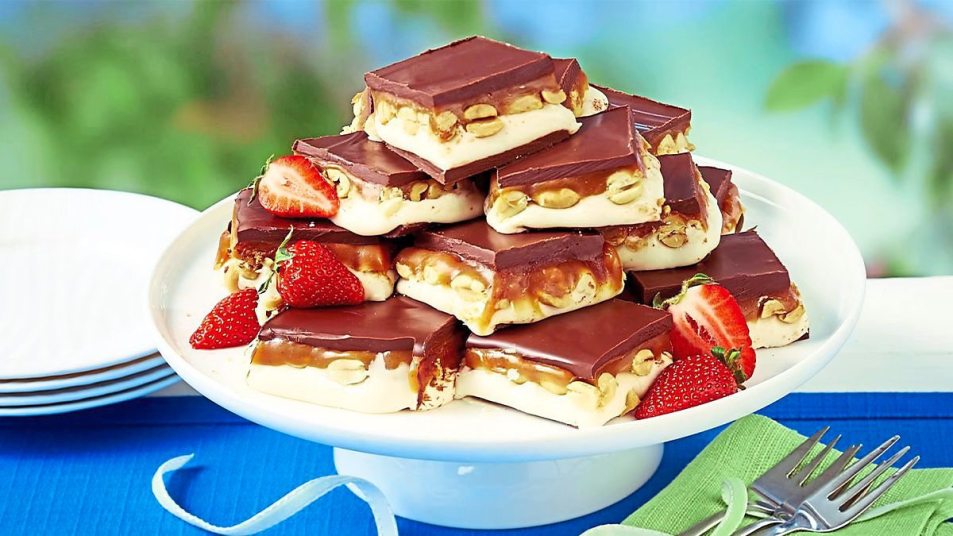 peanut butter desserts: Nutty Chocolate-Caramel Bars sits next to some strawberries