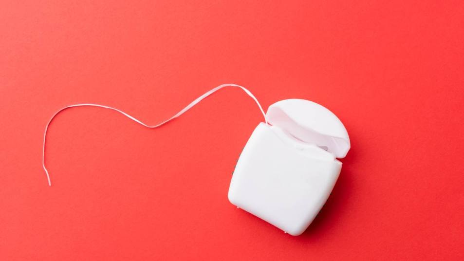 Uses For Dental Floss: Close-up of dental floss on pink background