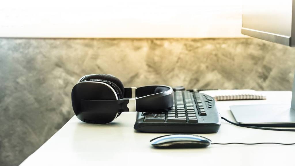 (Online transcription jobs for beginners) Headphones with desktop computer on the desk