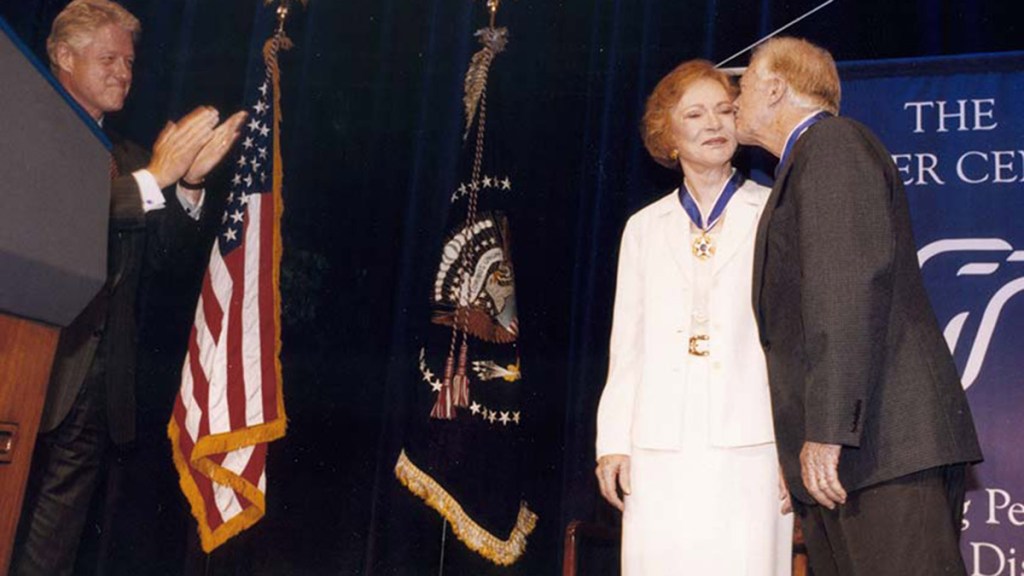Former President Jimmy Carter and former First Lady Rosalynn Carter receive the Presidential Medal of Freedom from President Bill Clinton at a ceremony at The Carter Center in Atlanta, Georgia, August 9, 1999