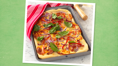 Cheesy Vegetable Pizza sits on a green background (Monday night dinner ideas )