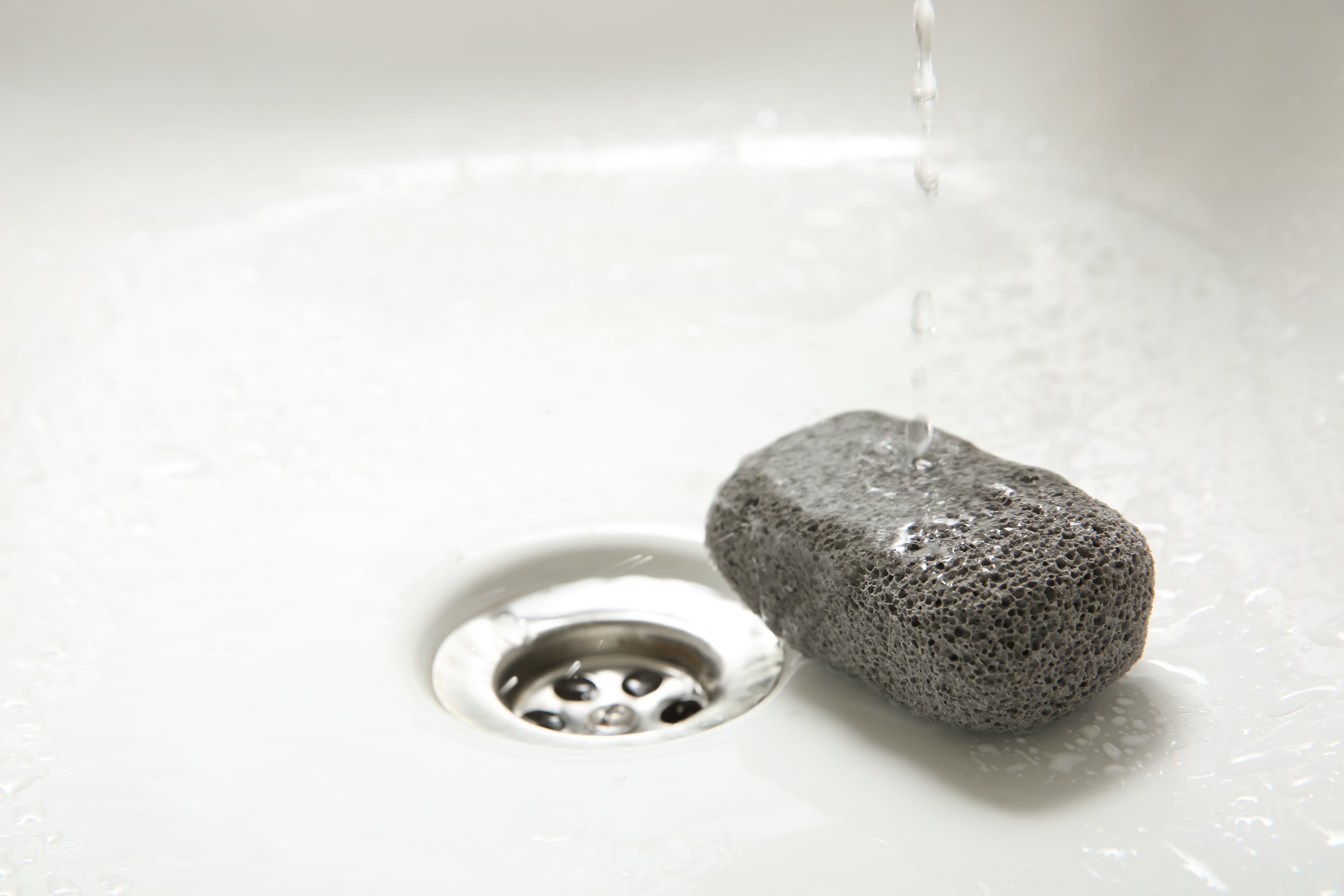 pumice stone in a sink with running water 