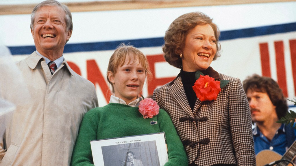 Former President Jimmy Carter acknowledges the crowd while standing on stage with his daughter Amy and wife Rosalynn upon the family's return to his hometown of Plains, Georgia, January 1981