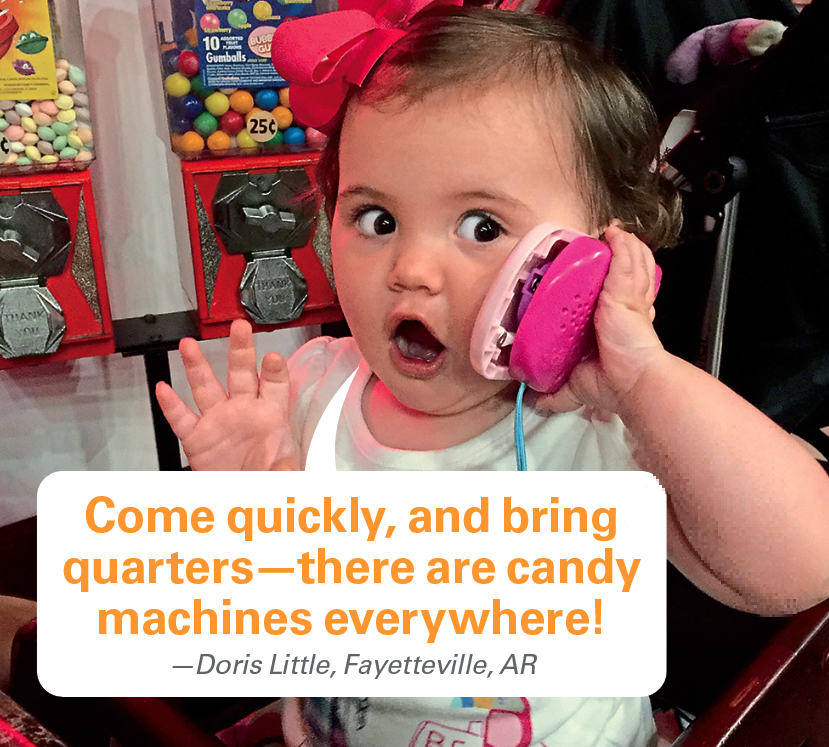 Caption contest winners: Toddler girl on phone with candy machines with caption "Come quickly, and bring quarters—there are candy machines everywhere!"