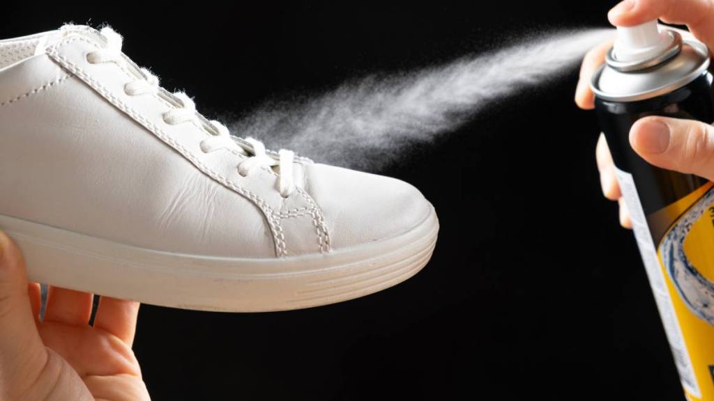 How to Make Shoes Non-Slip: Applying a water-repellent hydrophobic spray to white women's sneakers. Protection of shoes from moisture, dirt and unpleasant odor