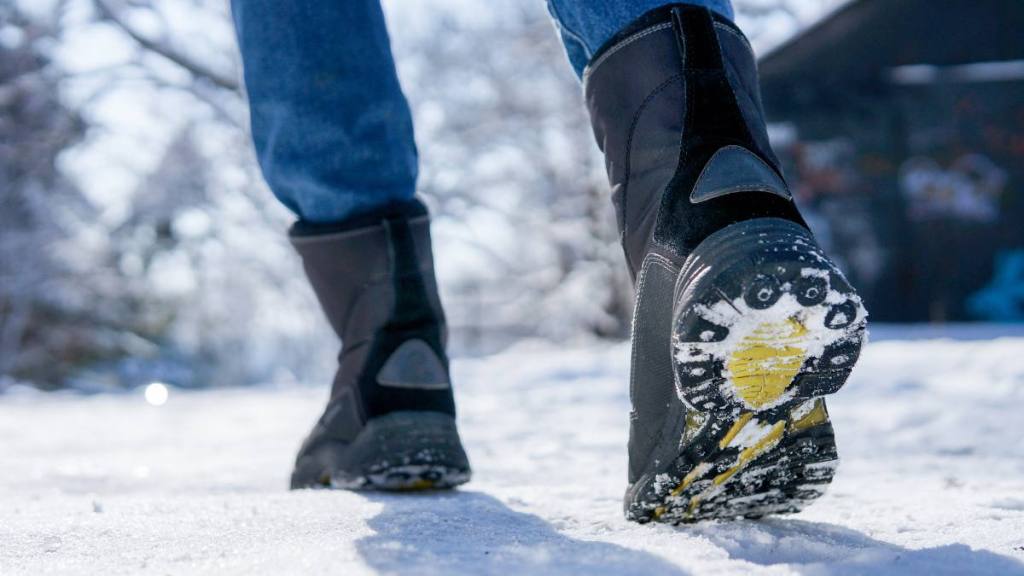 How to Make Shoes Non-Slip: female winter boots walking on snowy sleet road