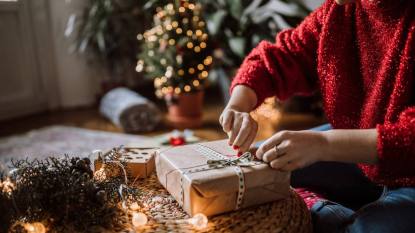 How to wrap a present without tape: Young Woman Wrapping Christmas Gifts In Living Room