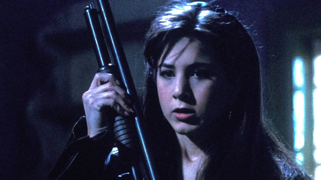 Jennifer Aniston holding a gun in "Leprechuan" Jennifer Aniston Young