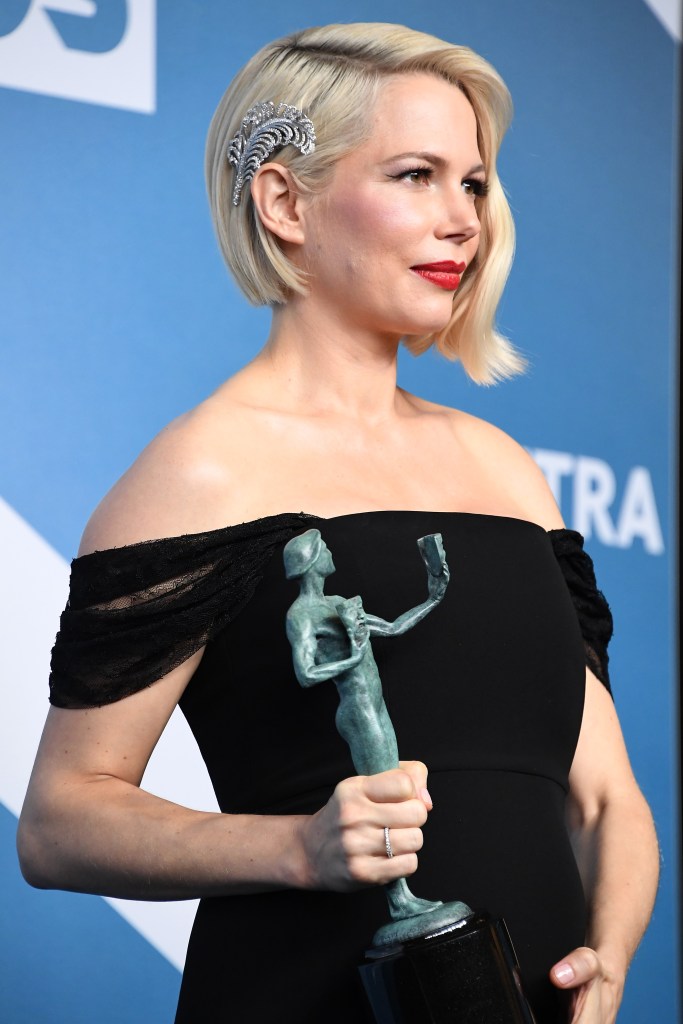 Michelle Williams poses in the press room wearing a black dress and rhinestone feather pin in her hair after winning the award for Outstanding Performance by a Female Actor in a Television Movie or Limited Series for "Fosse/Verdon" during the 26th Annual Screen Actors Guild Awards at The Shrine Auditorium on January 19, 2020 in Los Angeles, California