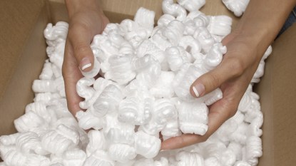 Woman's hands holding packing peanuts in box